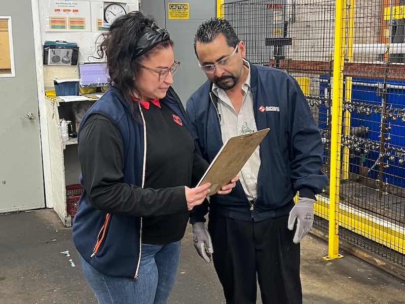 woman talking to a man on plating shop floor