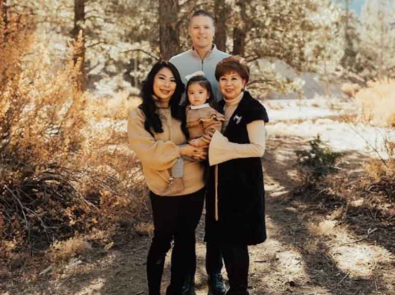 three adults and a child standing in the woods