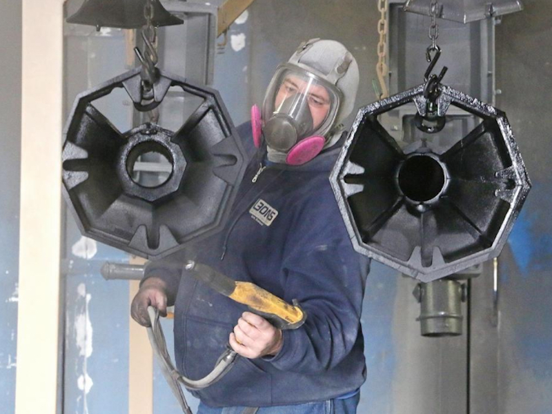 Leon's employee Ronald Julian spray paints the metal items with primer first.