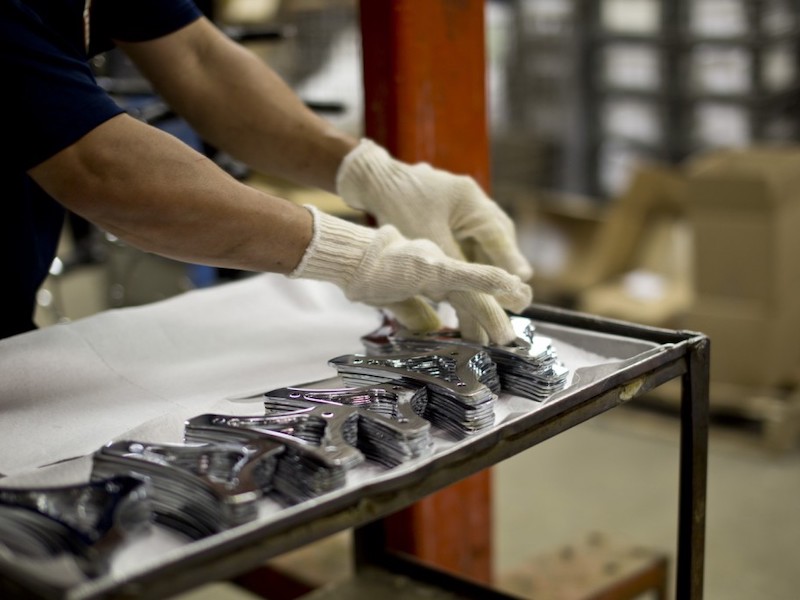 man putting chrome parts on a tray