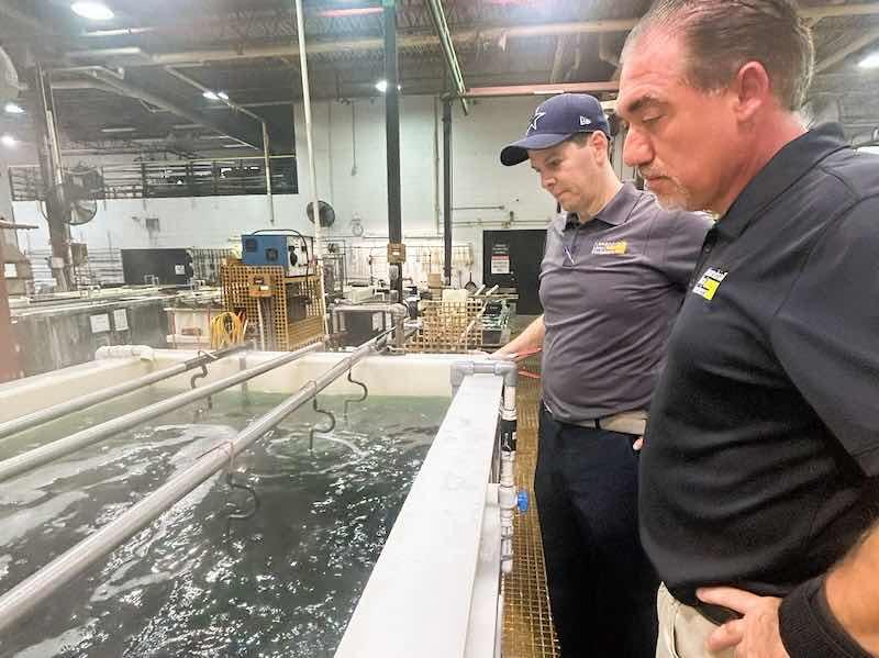 Alexandria Metal Finishers Plant Manager Dennis Capoccia, right, checks over the new tanks ans equipment that the company installed recently.