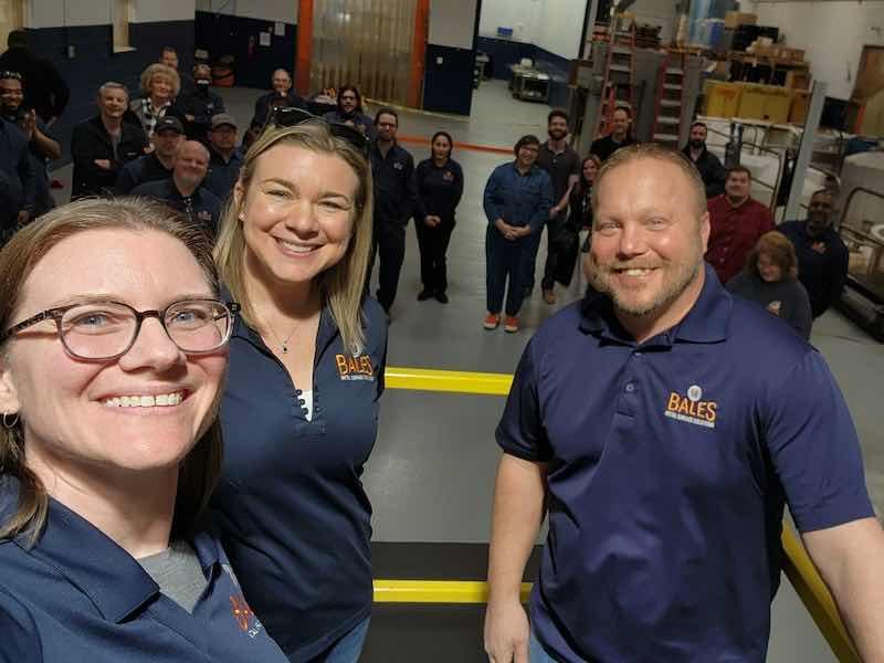 Owners Sara Mortensen and Stacey Bales, and Mike Hill, operations manager at Bales Metal Surface Solutions, celebrate the opening of their new lines.