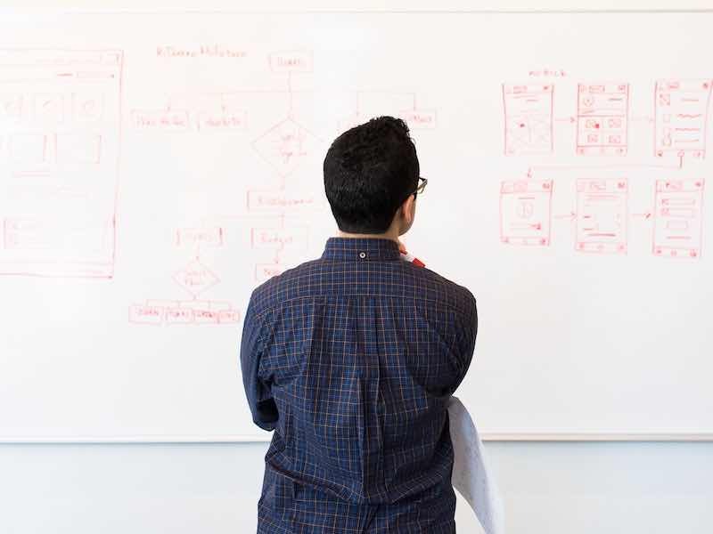 man looking at whiteboard