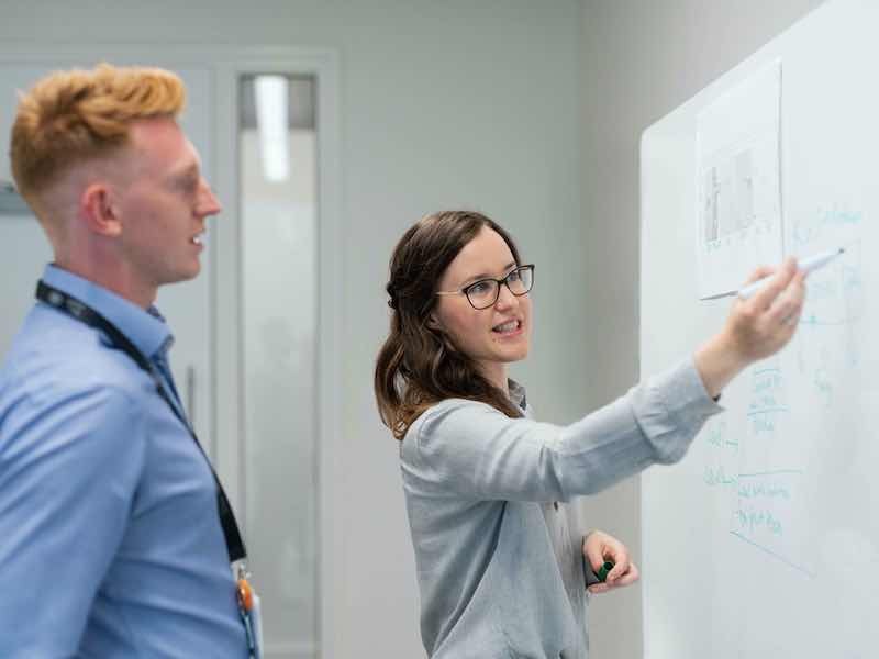 people working on a. whiteboard