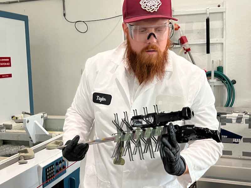 Taylor Clarke, Chemeonâs Process Chemist, examines parts being anodized.
