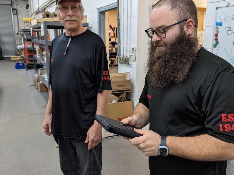 Anthony Nagy and John Spencer work on some of the equipment that is securing the Freedom Metal Finishing IT system.