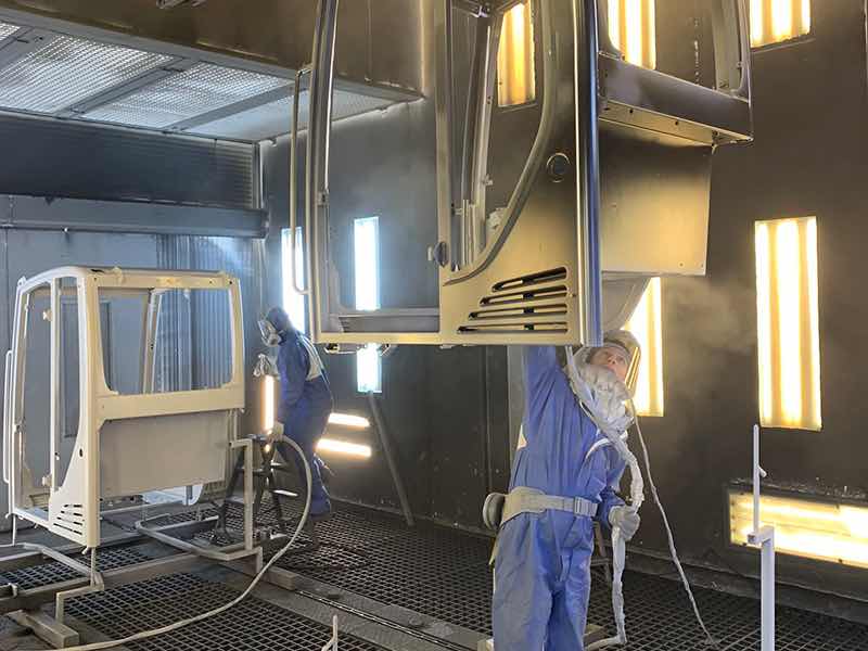 person spraying paint on equipment