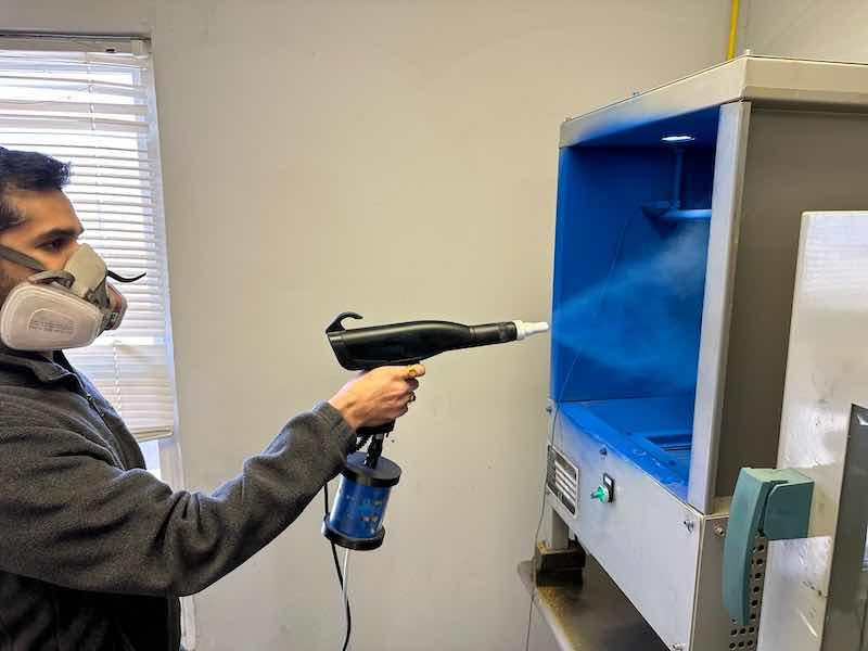 man spraying powder coating