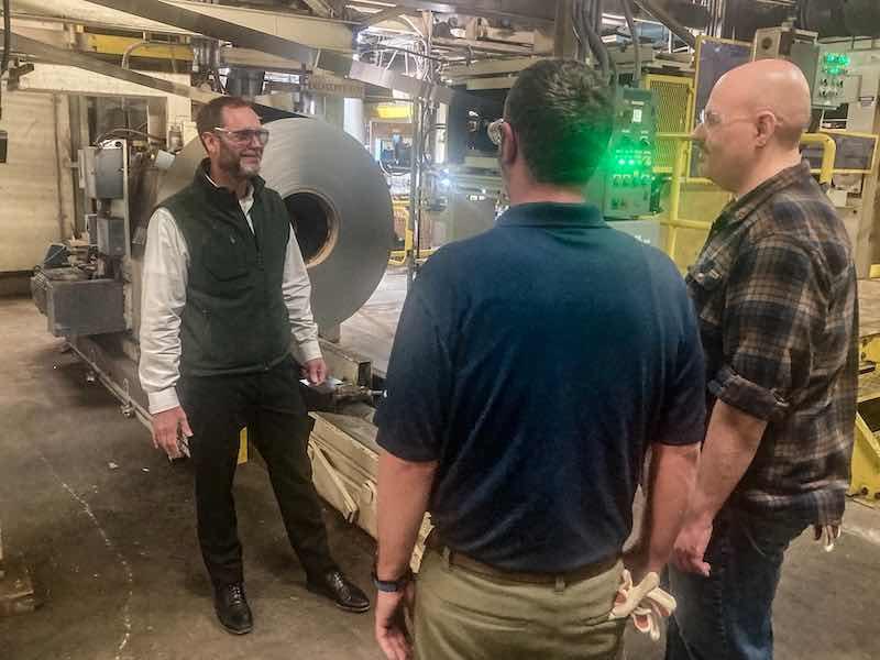 Park Kersman meets with some of his team members on the anodizing production floor.