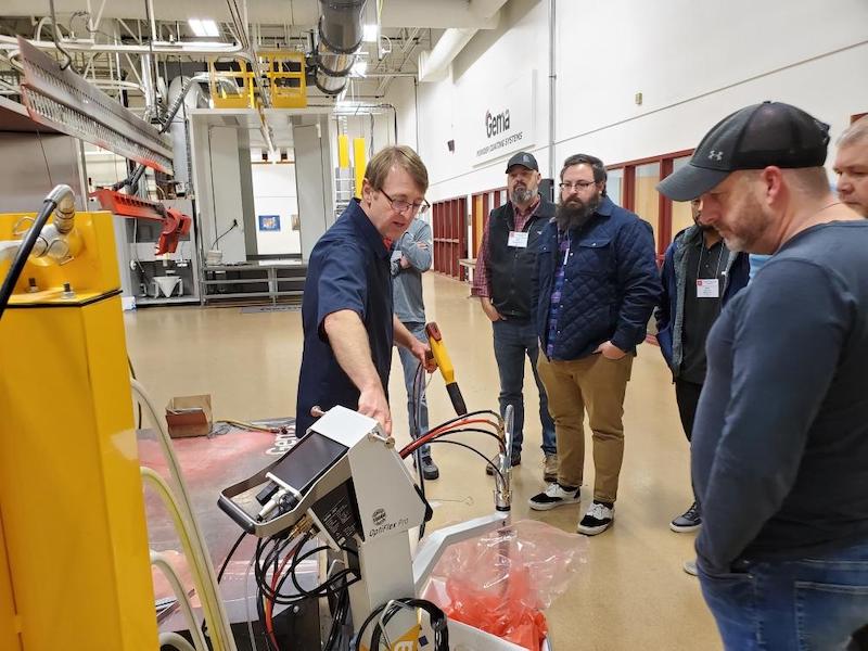 people watching an instructor on powder coating