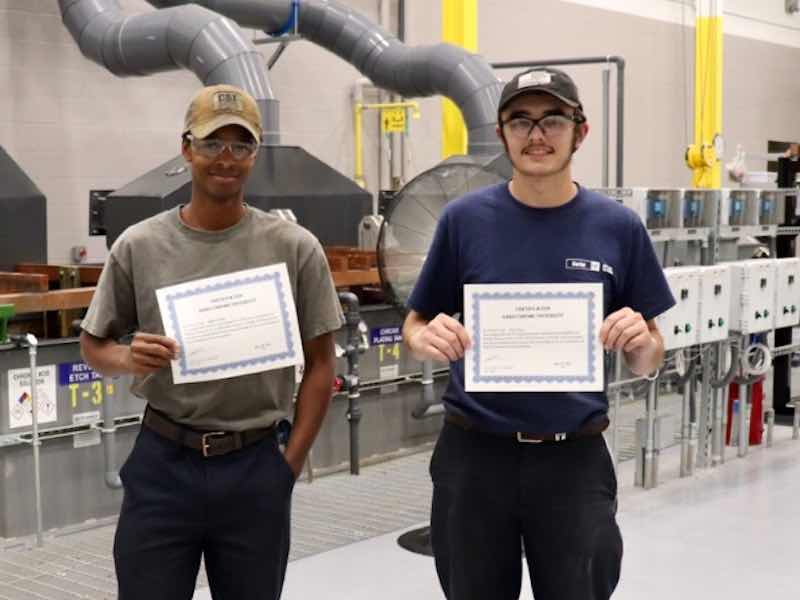 two people holding certificates