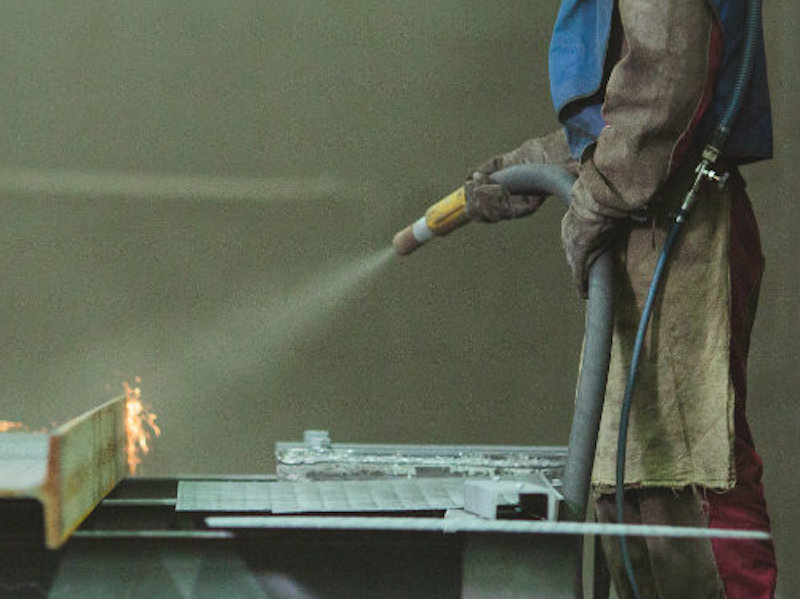 person doing shot peening