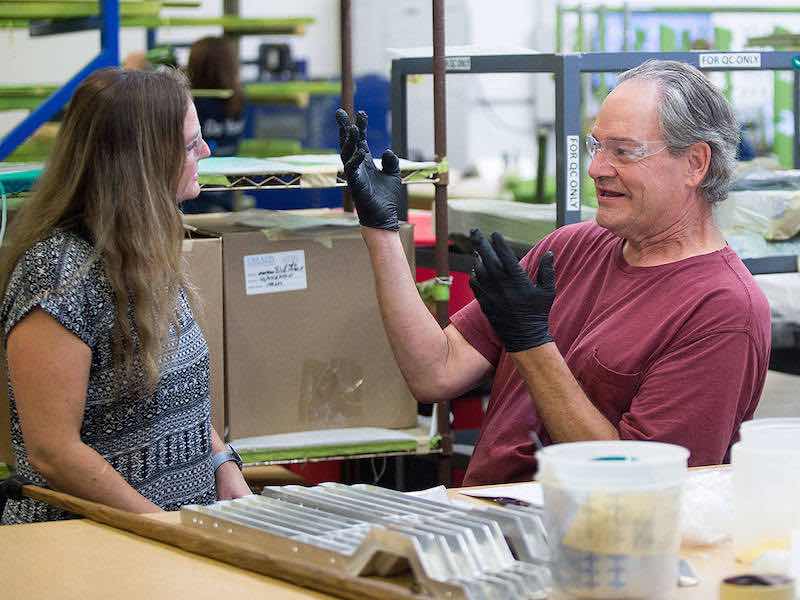 Using signs and a bit of lip-reading, masker Brian Jensen communicates with masking supervisor Patsy Caban at Valence Surface Technologies in Everett. (Andy Bronson / The Herald)
